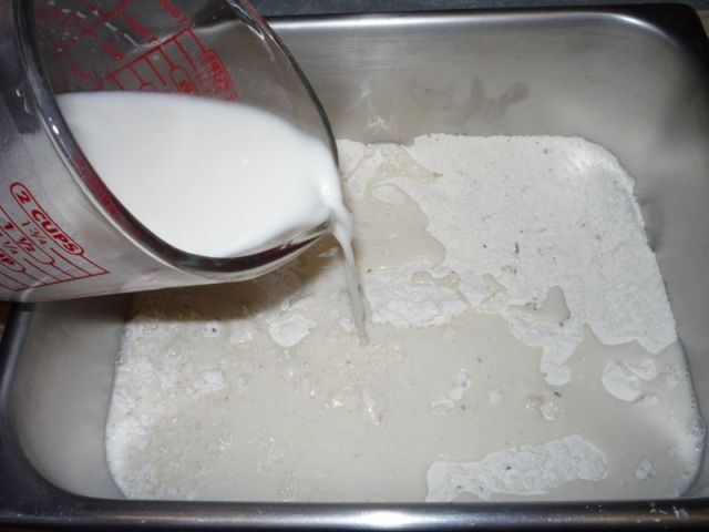 Pouring water and starter mixture into flour.