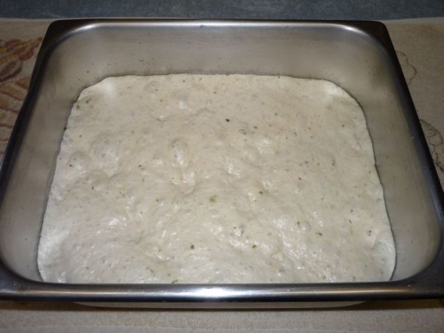 Pan with bubbly dough, which covers the entire bottom of pan.